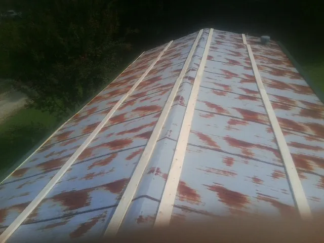 Rusted metal roof panels with new wood purlins before replacement — Storm Damage Roof Repair in White River Junction by Roofing Brothers