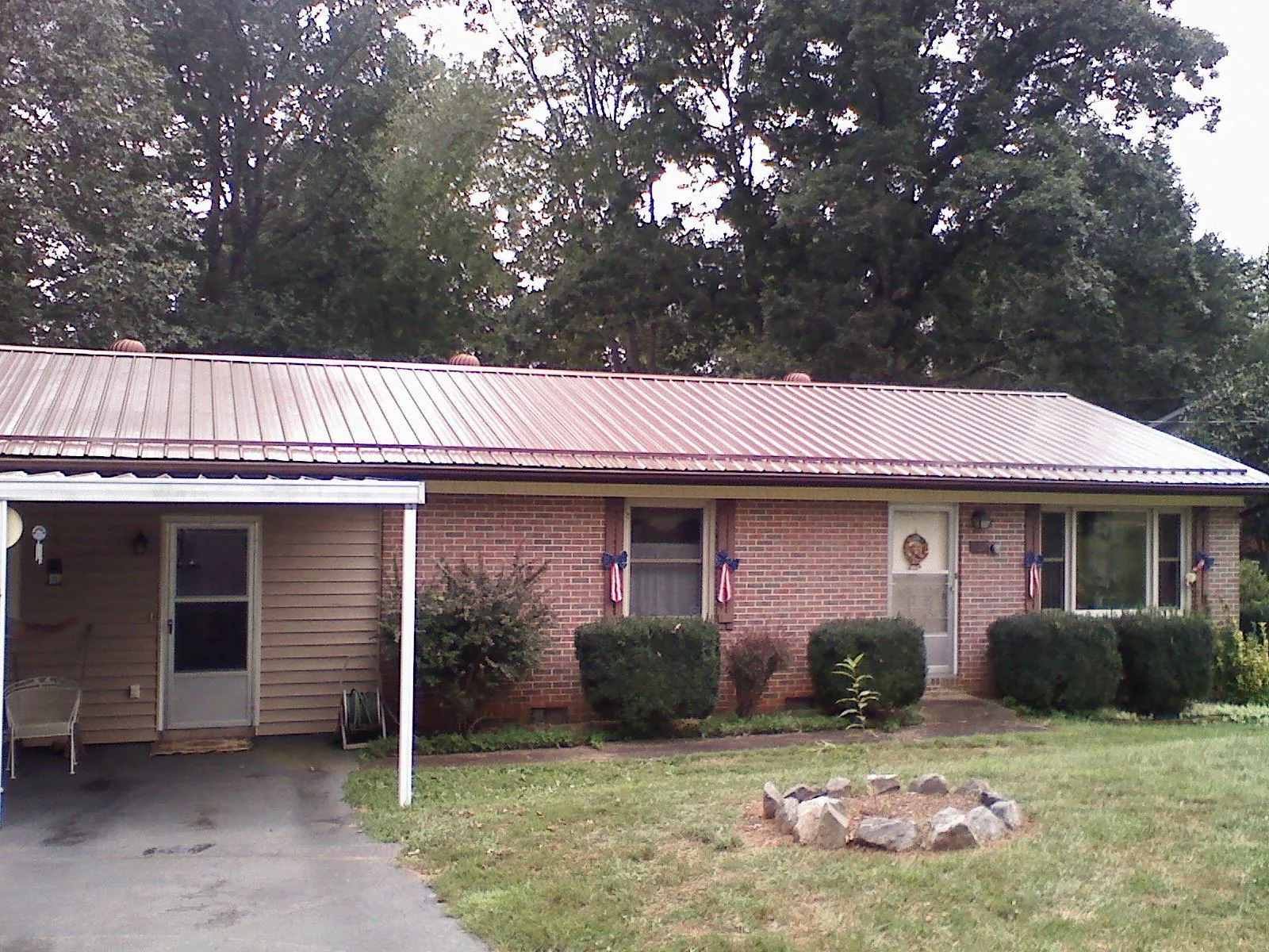 Bronze metal roof and carport on a brick ranch home — Roof Repair work by our crew in White River Junction