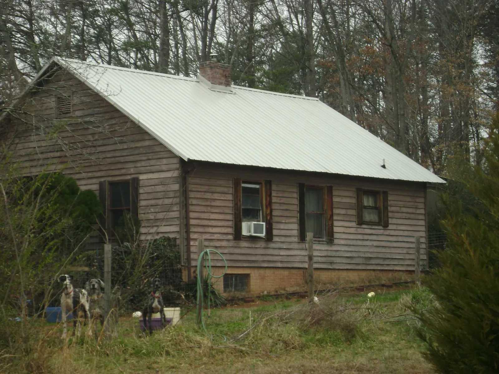 White metal roof on an old wood sided farmhouse, from a Metal Roof Installation job in White River Junction